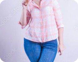 Woman in a loose pink plaid shirt and jeans with a fuller figure, representing the body type that weight loss therapy can help transform.
