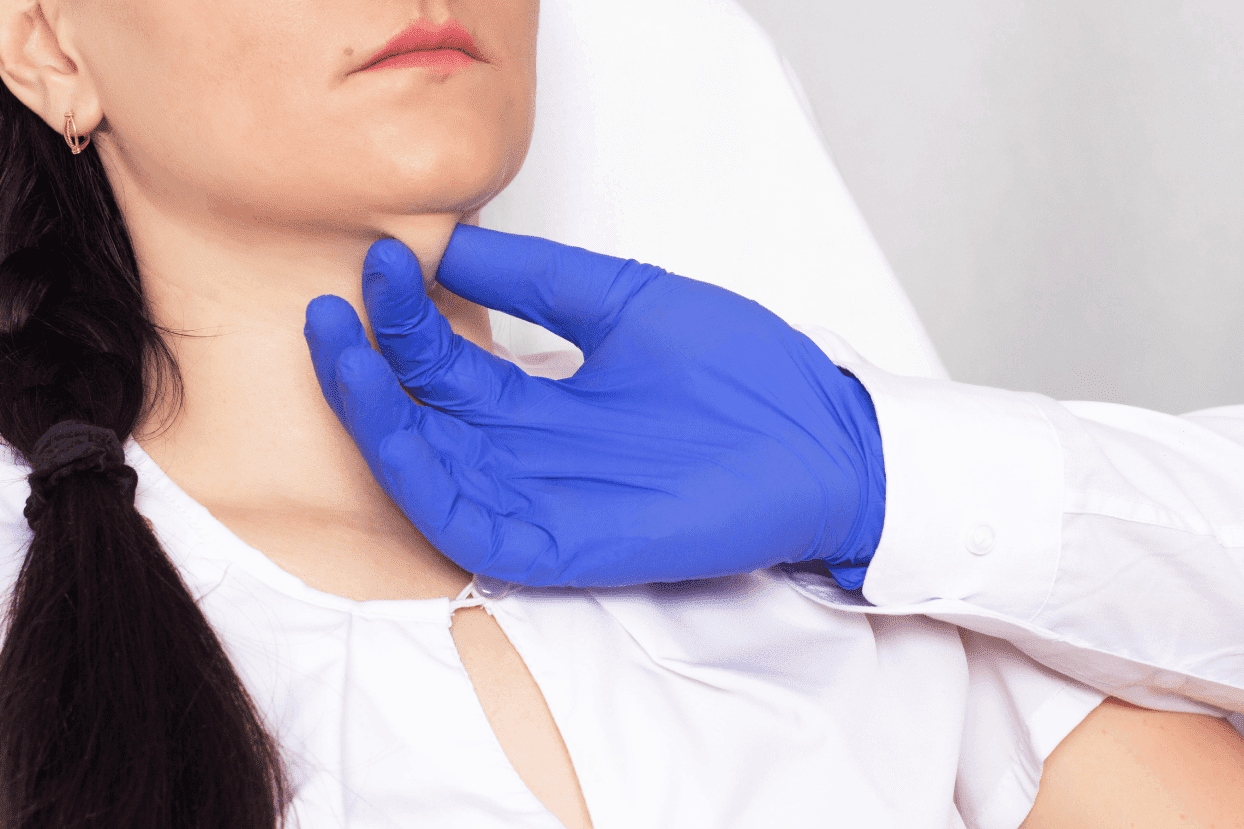 A gloved specialist examines a woman's neck and jawline area during a dermatological treatment consultation.