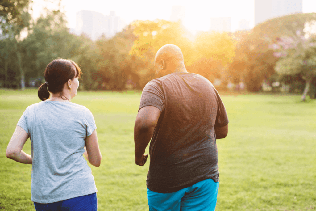 Man and woman walking in the park, potentially benefiting from a GLP-1 weight loss drug.